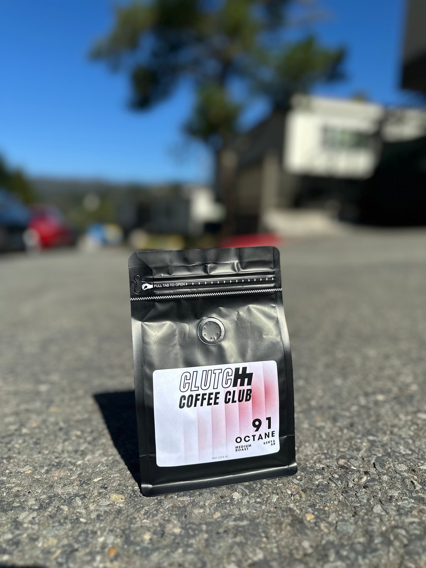 Coffee bag from Clutch Coffee Club on a street with a blurred background